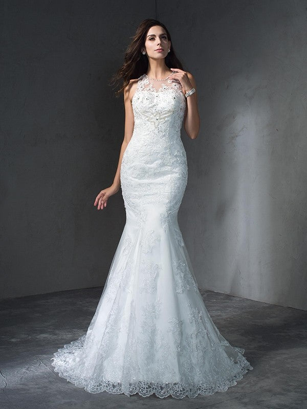 Robe de mariée longue en dentelle, style sirène/trompette, décolleté plongeant, sans manches, avec appliques