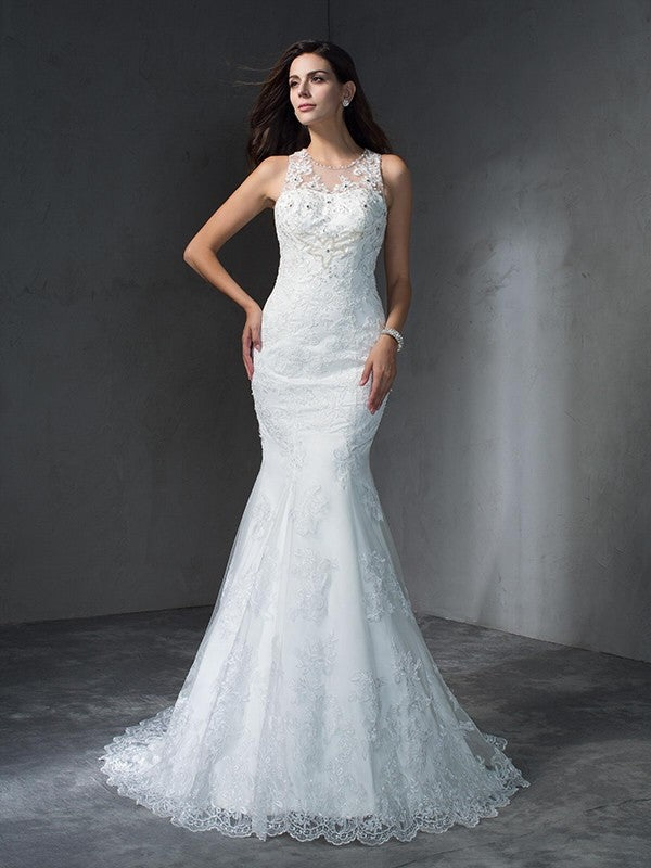 Robe de mariée longue en dentelle, style sirène/trompette, décolleté plongeant, sans manches, avec appliques