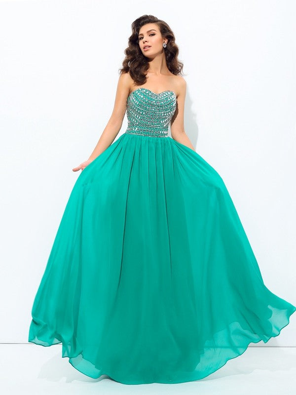 Robe longue en mousseline de soie, coupe trapèze/princesse, décolleté en cœur, perles, sans manches