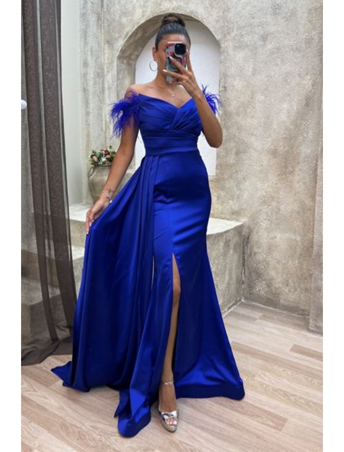 Full view of the chic A-line off-shoulder satin gown with high slit and feathers.