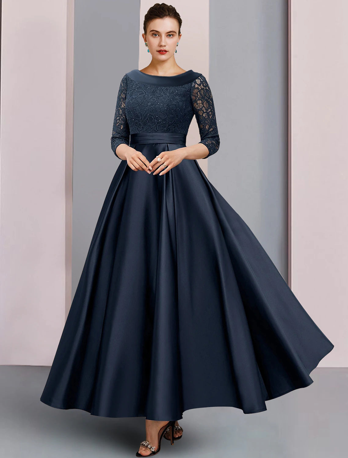 Model wearing an elegant A-line mother of the bride dress with bateau neck and 3/4 sleeves.