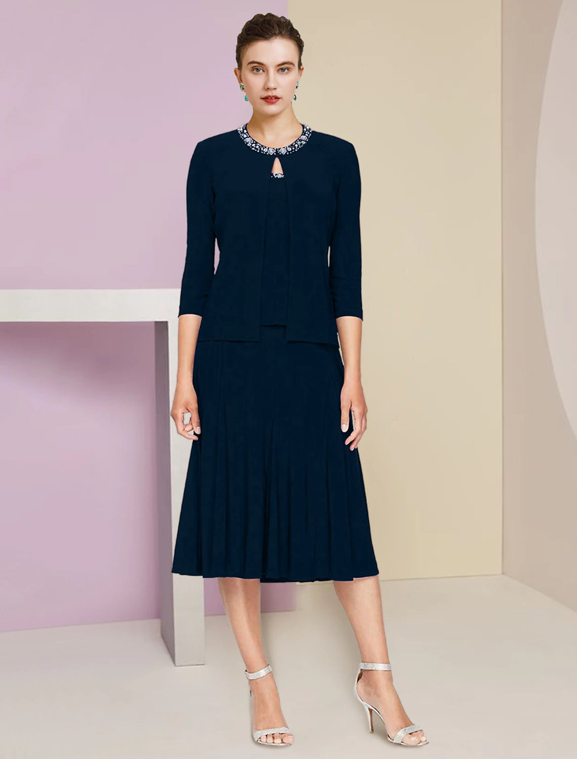 Elegant A-Line jewel neck dress with 3/4 sleeves, pleats, and crystals.
