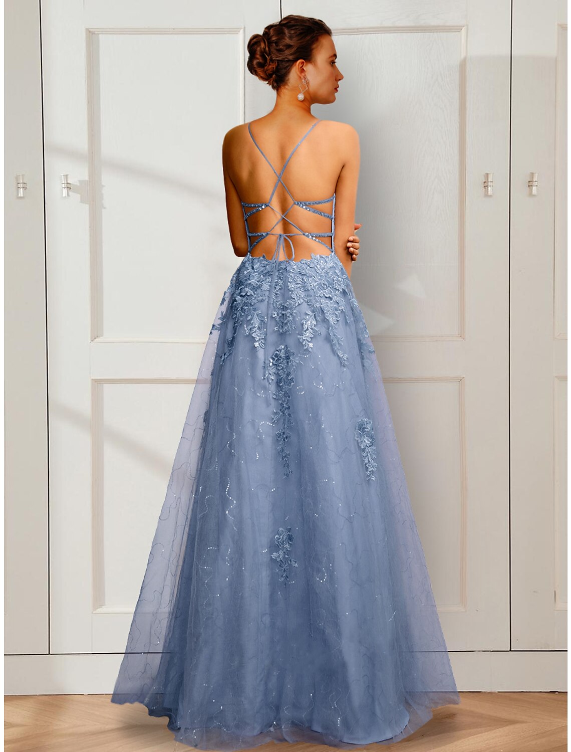 Model wearing a floor-length A-Line spaghetti strap prom dress.