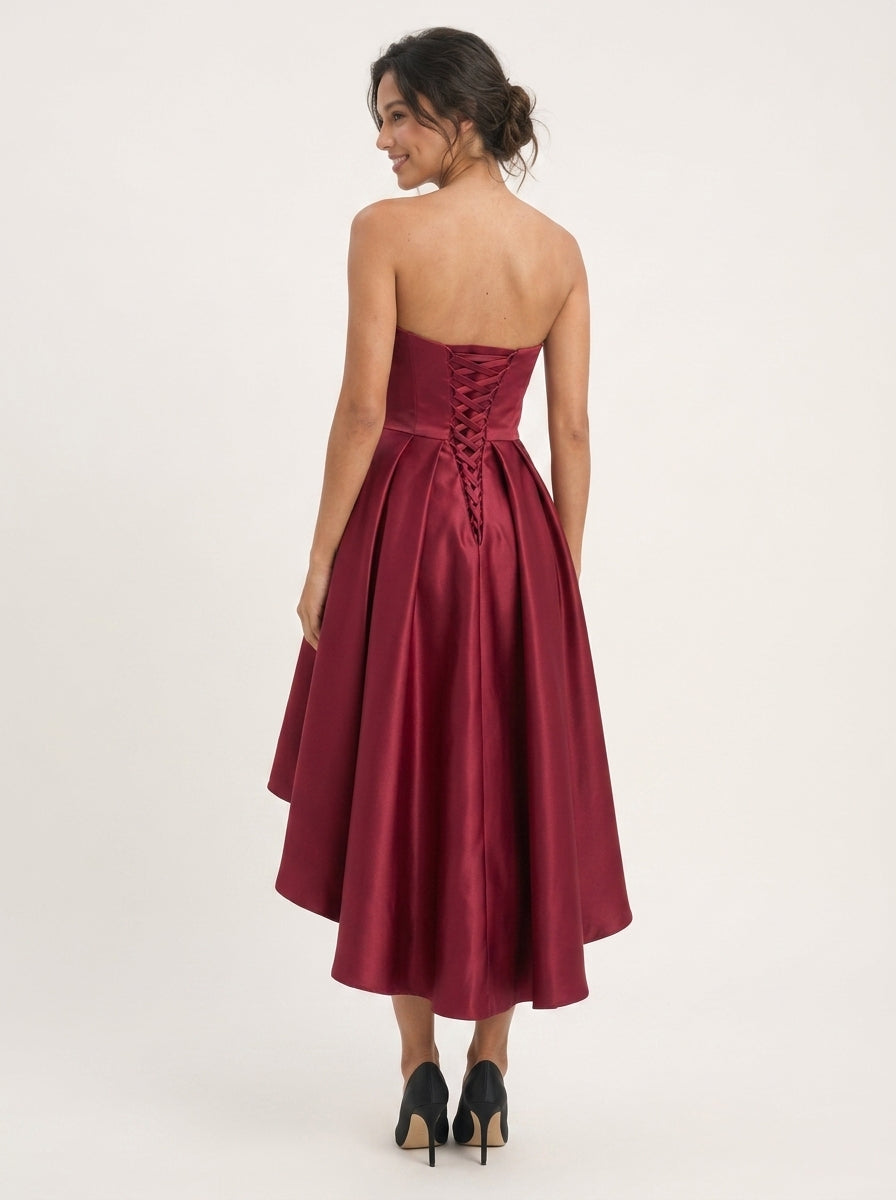 Back view of the burgundy high-low dress, showcasing the lace-up corset detail.