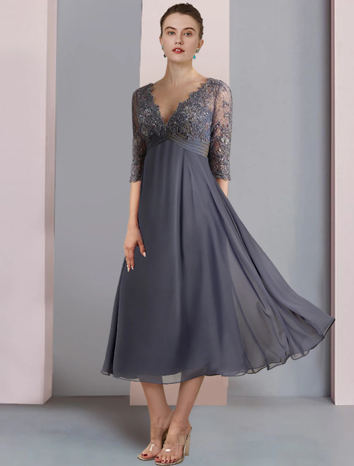 Model wearing an elegant A-line V-neck half sleeve tea length Mother of the Bride dress with beading and sequins.