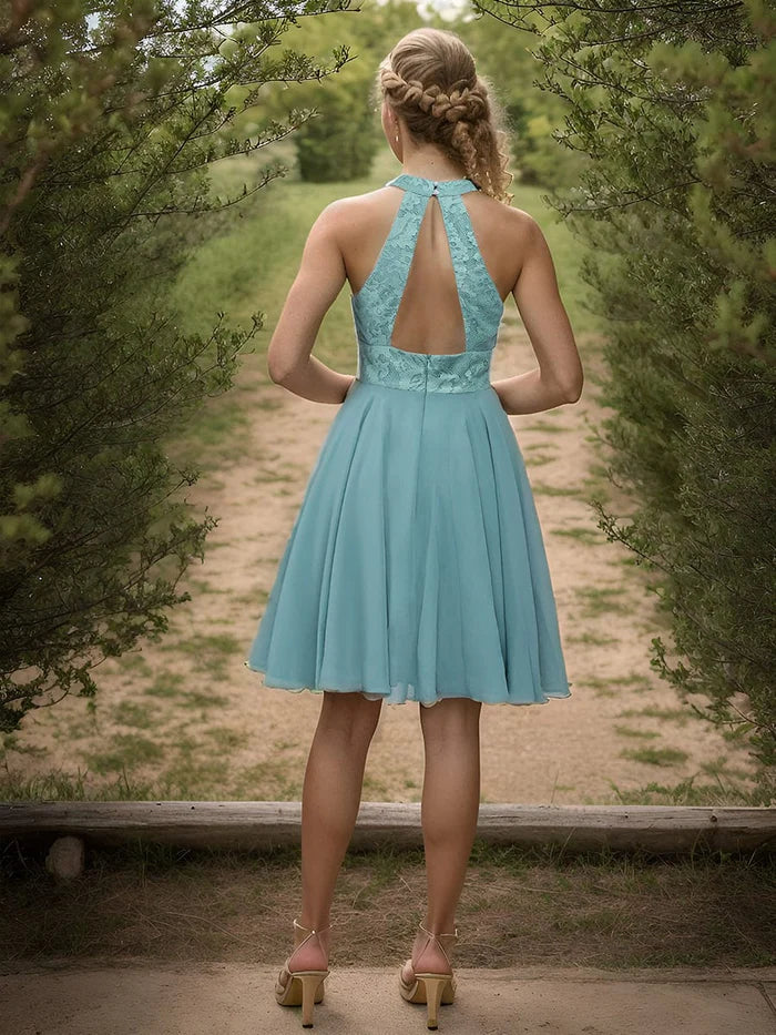 Model posing in the short chiffon homecoming dress with a lace halter neckline.
