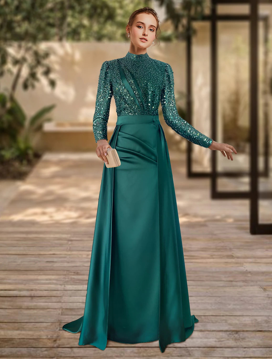 Model wearing an elegant green sheath formal gown with long sleeves, jewel neck, and a sweep train.