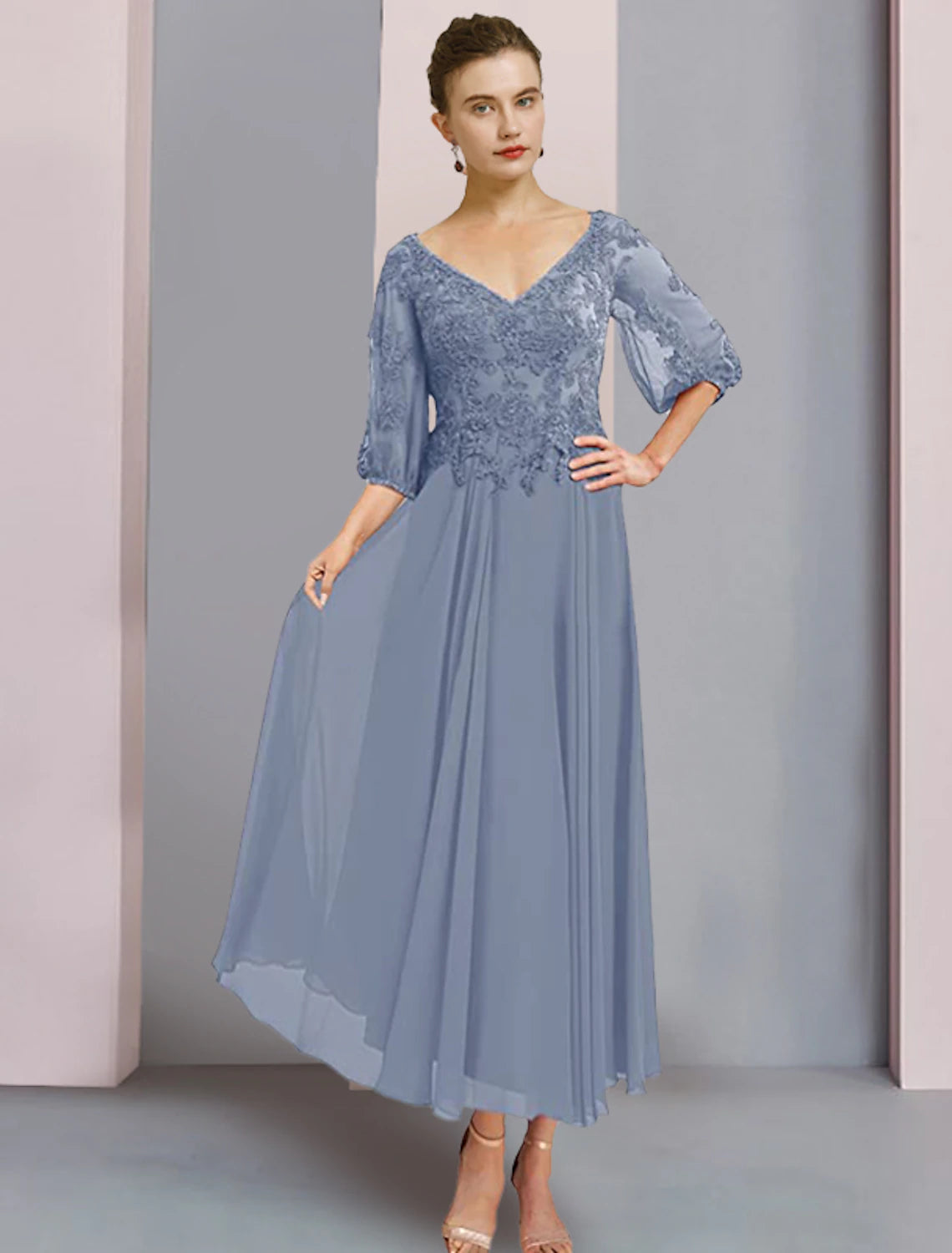 Model wearing an elegant blue two-piece A-line mother of the bride dress with V-neck and 3/4 lace sleeves.