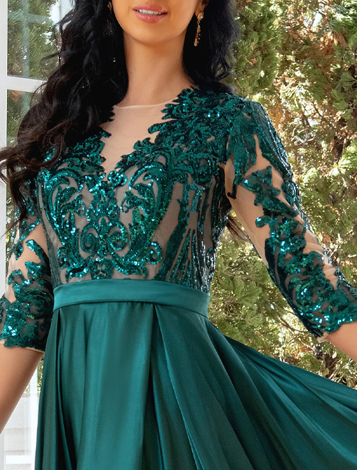 Close-up of the illusion neckline and half sleeve on the sparkling gown.