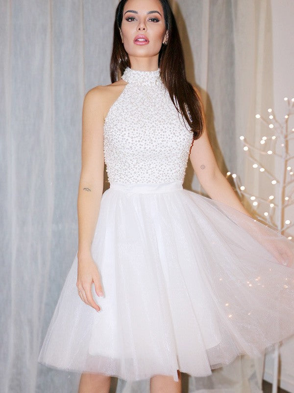 Sparkling A-line halter homecoming dress with beading and tulle.