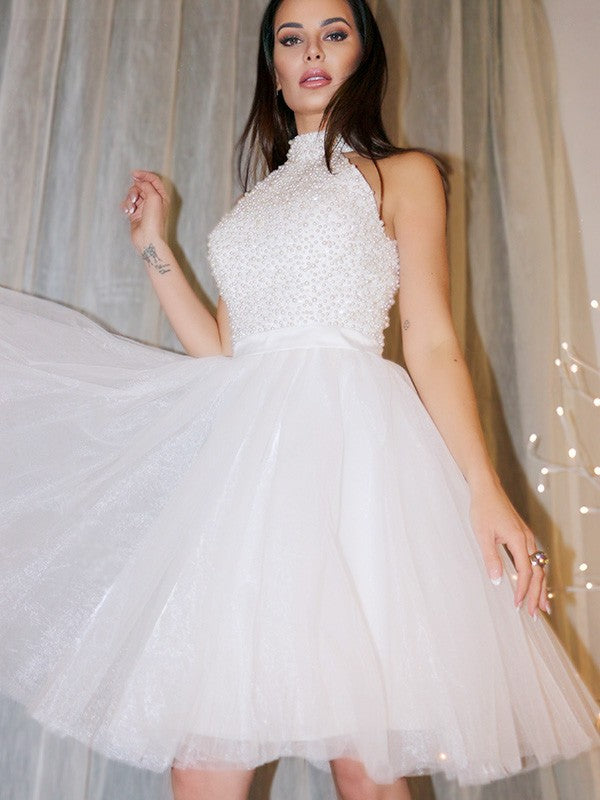 Close-up of the halter neckline and intricate beading on the tulle homecoming dress.