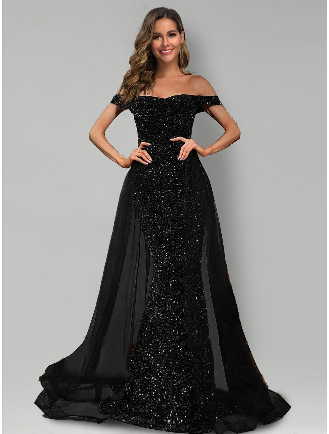 Model wearing a sparkling black mermaid evening gown with off-shoulder neckline and sequin tulle.