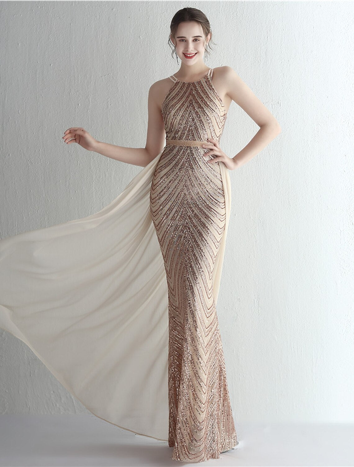 Side profile of a woman in a floor-length mermaid prom dress.
