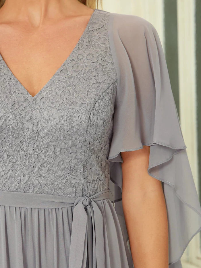 Robe de soirée longue et fluide avec décolleté en V profond et corsage en dentelle 