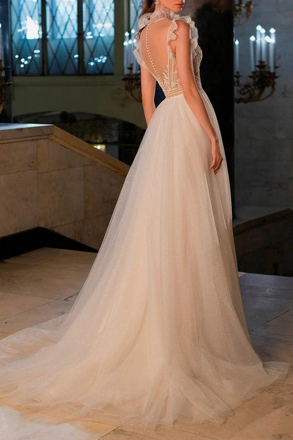 A bohemian wedding dress with a thread illusion and sparkling beads at the neckline