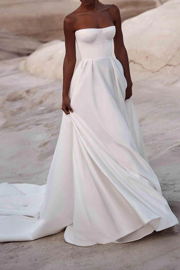 Une robe de mariée en satin blanc avec des lignes de traîne de palais et sans bretelles