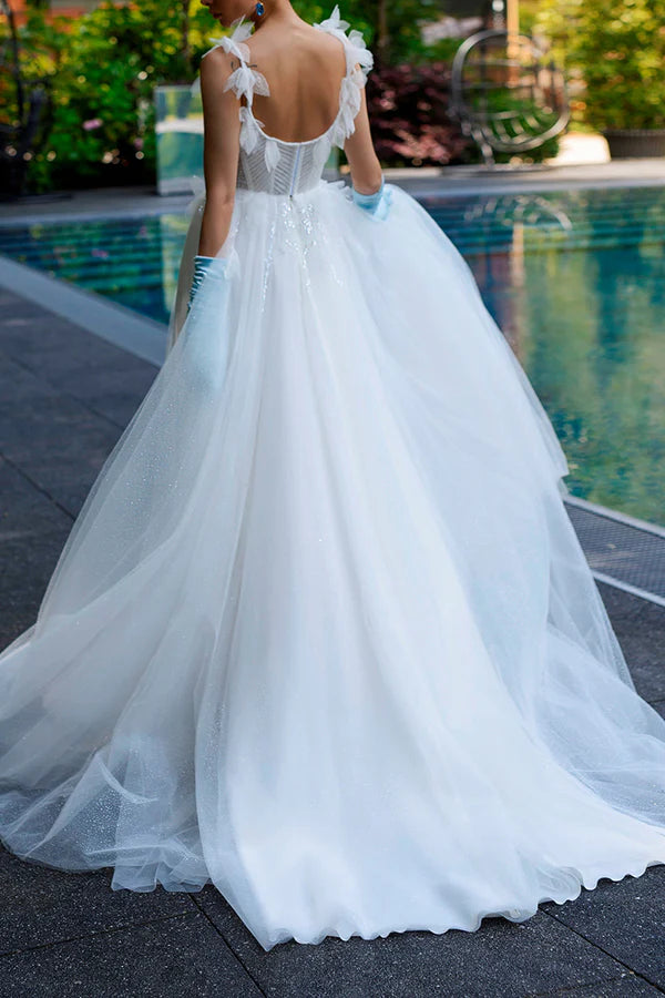 A simple wedding dress with thin shoulder straps, spoonful beads and a single thread