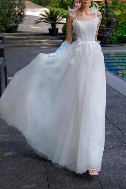A simple wedding dress with thin shoulder straps, spoonful beads and a single thread